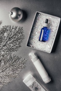 serum hediye kutusu, losyon, micellar su ve Noel top üstten görünüm üzerinde gümüş 