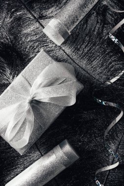 siyah tüylü tarafından gümüş kaplı yüzeyinde Noel hediye kutusu, losyon, micellar su ve şerit üstten görünüm 
