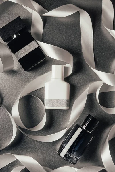 Top View Bottled Perfumes White Ribbons Grey — Stock Photo, Image