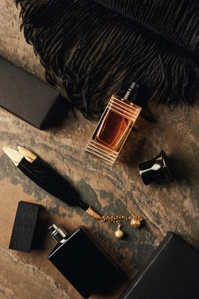 棕色风化表面的香水瓶 盒子和装饰黑色羽毛 — 图库照片