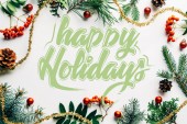 plochý ležela s slavnostní uspořádání borovice větví, společné moře Frangula Alnus, Rhamnaceae a vánoční ozdoby na bílou desku s happy holidays nápisy