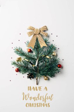 top view of green pine branch decorated as festive christmas tree with bow on white background with 