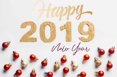 top view of 2019 year golden sign and christmas balls on white background with 