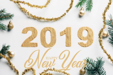 top view of 2019 year sign, pine branches, golden garlands and christmas balls on white background with 