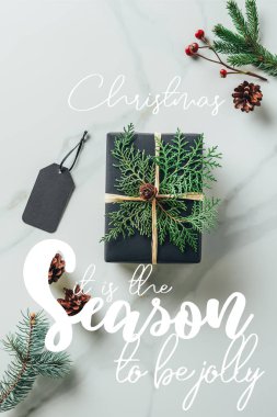 top siyah Noel hediye kutusu çam dalları ile görünümünü ve mermer tablo etiketi 