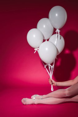 oturma ve beyaz balon demeti burgundy üzerinde partide tutan kız kırpılmış görüntü