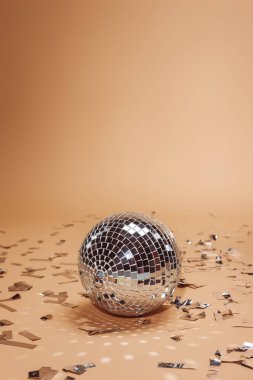 parlak gümüş disko topu ve konfeti üzerinde bej