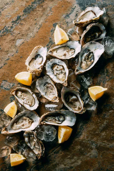 Samenstelling Van Levensmiddelen Van Oesters Citroen Stukken Ijs Grungy Tafelblad — Stockfoto