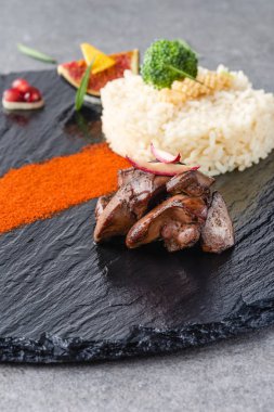 pirinç, brokoli, incir ve siyah plaka ve taş yüzey üzerinde kızarmış et 
