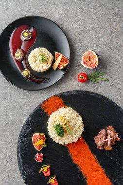 siyah plakalar üzerinde pirinç, brokoli, incir ve soslu kızarmış et Üstten Görünüm