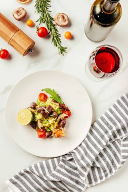 cam ve bir şişe şarap ve bir bez ile beyaz tabakta salatası Üstten Görünüm