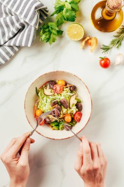 çatal ve bıçak salata yiyen kadın görünümünü kırpılmış 