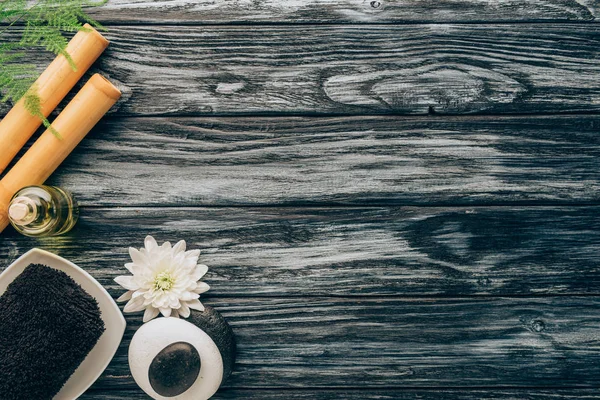 Top view of arranged spa and massage accessories with towel, pebbles and bamboo sticks on wooden background — Stock Photo