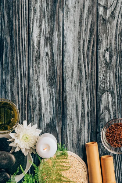 Top view of arranged pebbles, oil, salt and bamboo sticks for spa and massage on wooden background — Stock Photo