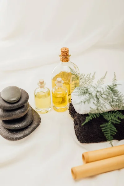 Nahaufnahme der Anordnung von Wellness-Zubehör mit Handtüchern, Kieseln und ätherischem Öl auf weißem Hintergrund — Stockfoto