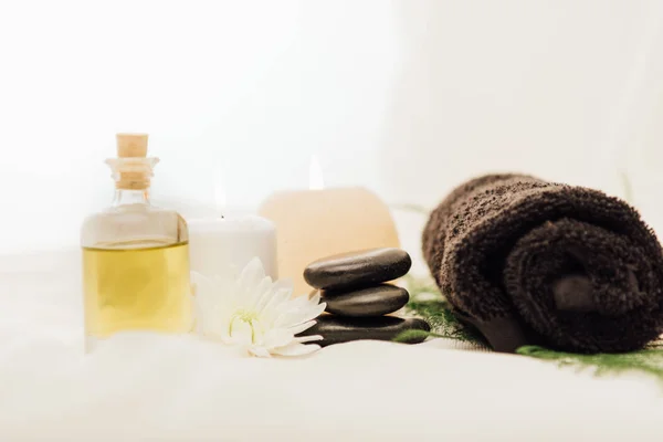 Vue rapprochée de la disposition des accessoires de traitement spa avec des bougies et des cailloux sur fond blanc — Photo de stock