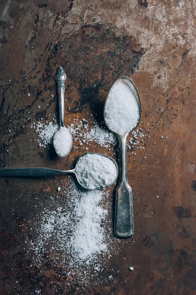 Vue de dessus de trois cuillères en argent avec du sel sur la table — Photo de stock