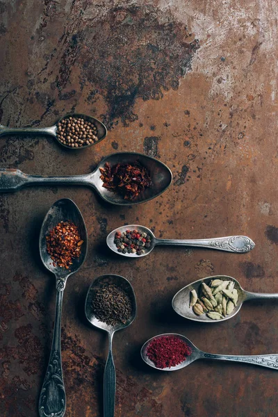 Top view of spices in spoons on grungy tabletop — Stock Photo