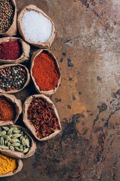 Elevated view of colorful spices in paper bags on table — Stock Photo