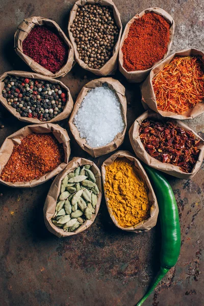 Vista elevada de especias indias en bolsas de papel en la mesa — Stock Photo