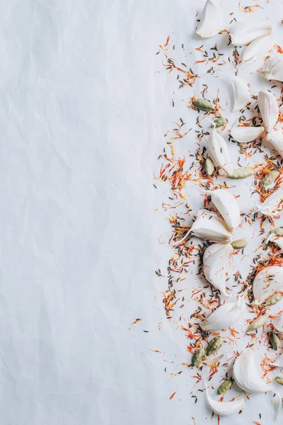 Von oben verstreuter Knoblauch und Gewürze auf weißem Tisch — Stockfoto