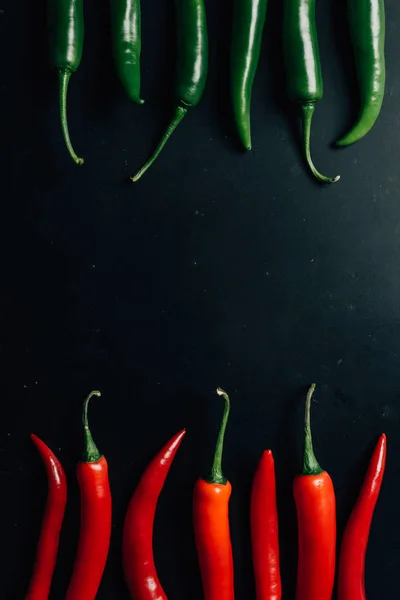 Ansicht von roten und grünen Chilischoten auf dunklem Tisch — Stockfoto