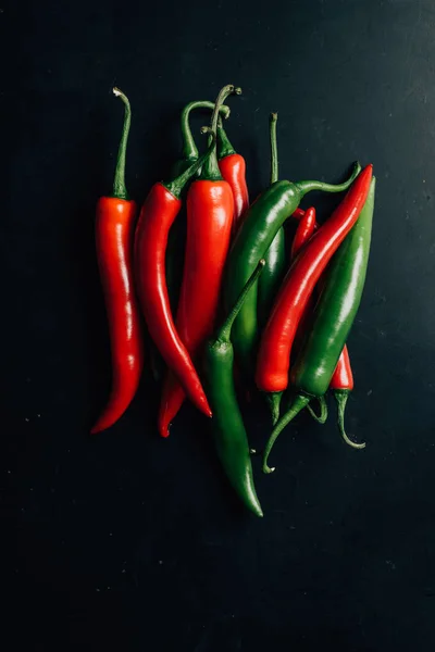 Vista superior de los chiles rojos y verdes en la mesa - foto de stock