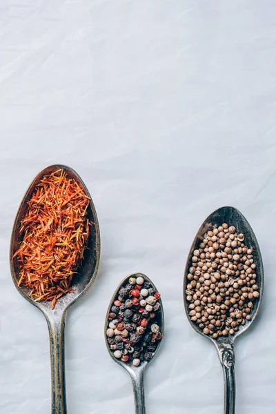 Top view of indian spices in spoons on white table — Stock Photo
