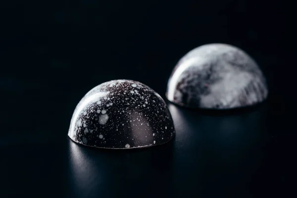 Vue rapprochée de deux bonbons au chocolat sur fond noir — Photo de stock