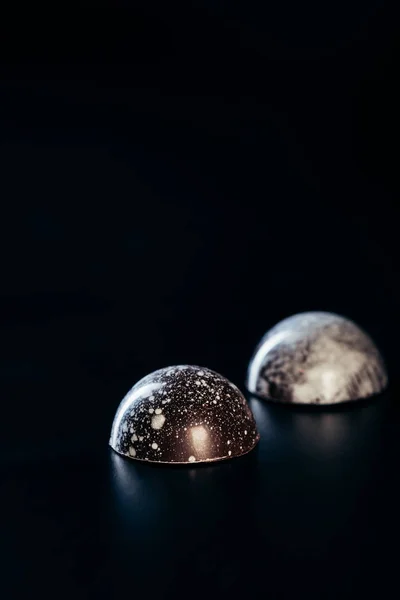 Vista da vicino di due caramelle al cioccolato su sfondo nero — Foto stock