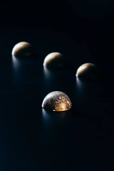 Imagem de perto de doces de chocolate no fundo preto — Fotografia de Stock