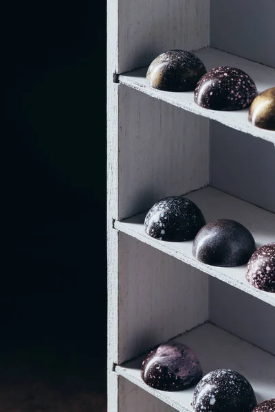 Diferentes caramelos de chocolate colocados en filas en estantes - foto de stock