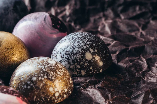 Closeup view of various chocolate candies on crumpled paper — Stock Photo