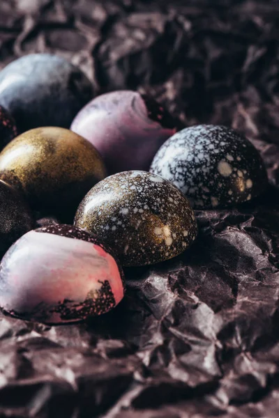 Pile of various chocolate candies on crumpled paper — Stock Photo