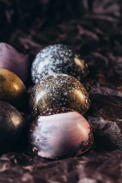 Vista close-up de pilha de diferentes doces de chocolate em papel amassado — Fotografia de Stock