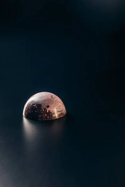 Close up imagem de chocolate doce com salpicos de rosa no fundo preto — Fotografia de Stock