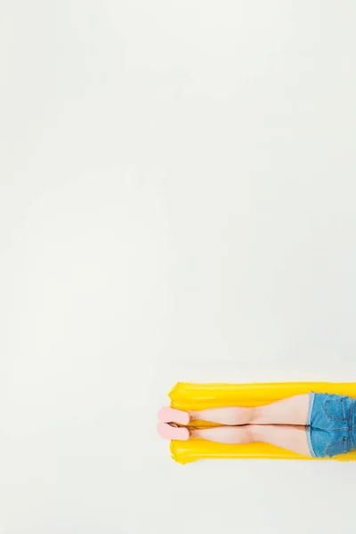 Abgeschnittene Aufnahme einer Frau, die auf einer aufblasbaren Matratze liegt, isoliert auf weiß — Stockfoto