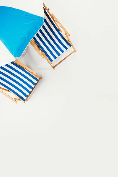 Vista superior de guarda-chuva de praia e cadeiras de praia listradas isoladas em branco — Fotografia de Stock