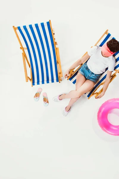 Вид зверху на жінку, що відпочиває на пляжному стільці ізольовано на білому, концепція літніх канікул — стокове фото