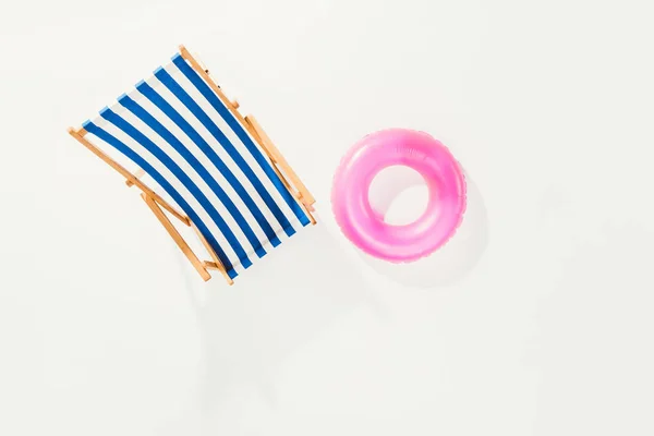 Vista superior de la silla de playa a rayas y anillo inflable aislado en blanco - foto de stock