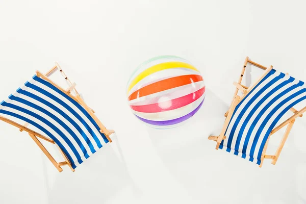 Вид зверху смугастих пляжних стільців і надувного м'яча ізольовані на білому — стокове фото