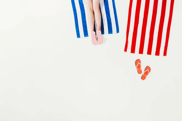 Cropped shot of person resting on striped beach towel isolated on white — Stock Photo