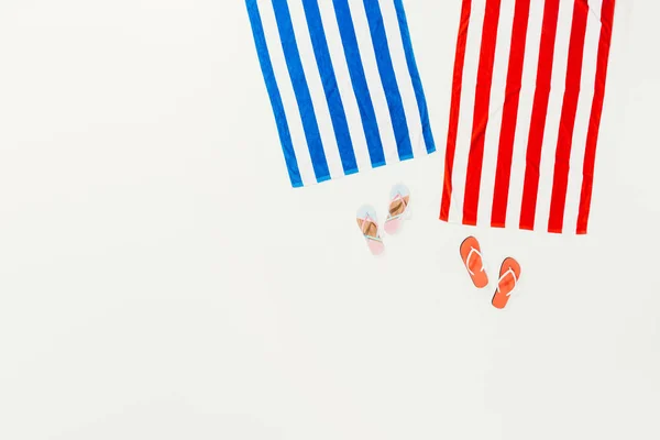 Top view of striped towels and flip flops isolated on white — Stock Photo