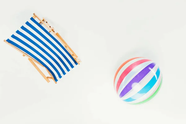 Vue de dessus de chaise de plage rayée et ballon de plage gonflable isolé sur blanc — Photo de stock