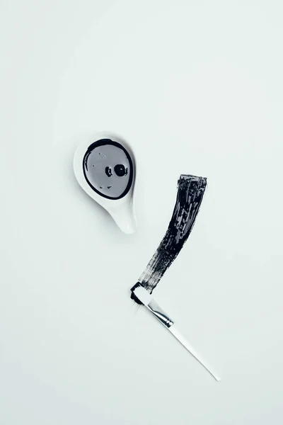 Draufsicht auf schwarze Maske und Pinsel isoliert auf weißer Oberfläche — Stockfoto