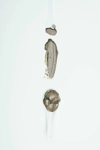 Top view of spoons and clay mask smudge isolated on white surface — Stock Photo