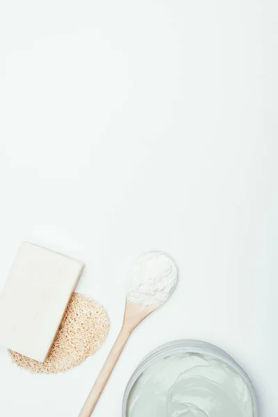 Deitado plano com sabão, esponja, colher, máscara de argila em recipiente e pó de argila isolado na superfície branca — Fotografia de Stock