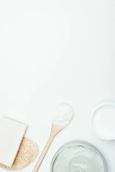 Deitado plano com sabão, esponja, colher, máscaras de argila em recipientes e pó de argila isolado na superfície branca — Fotografia de Stock