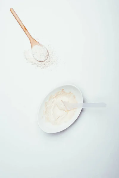 Top view of spoons, clay powder and plate with clay mask isolated on white surface — Stock Photo