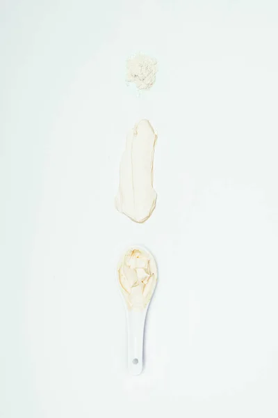 Вид зверху на глиняний порошок, розчин і ложку з глиняною маскою ізольовані на білій поверхні — стокове фото